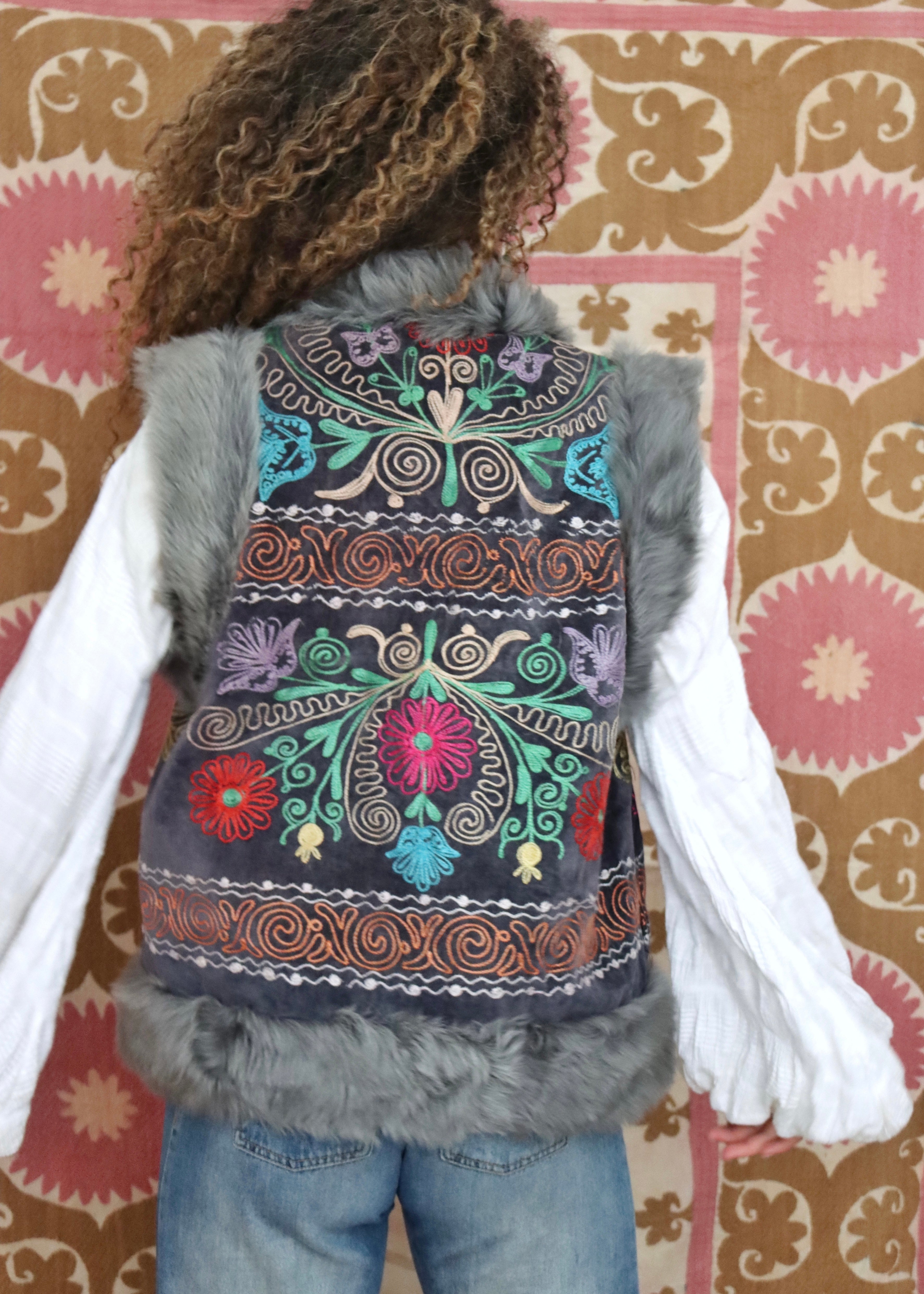 model wearing vintage grey suzani with multicoloured embroidery and fur trim