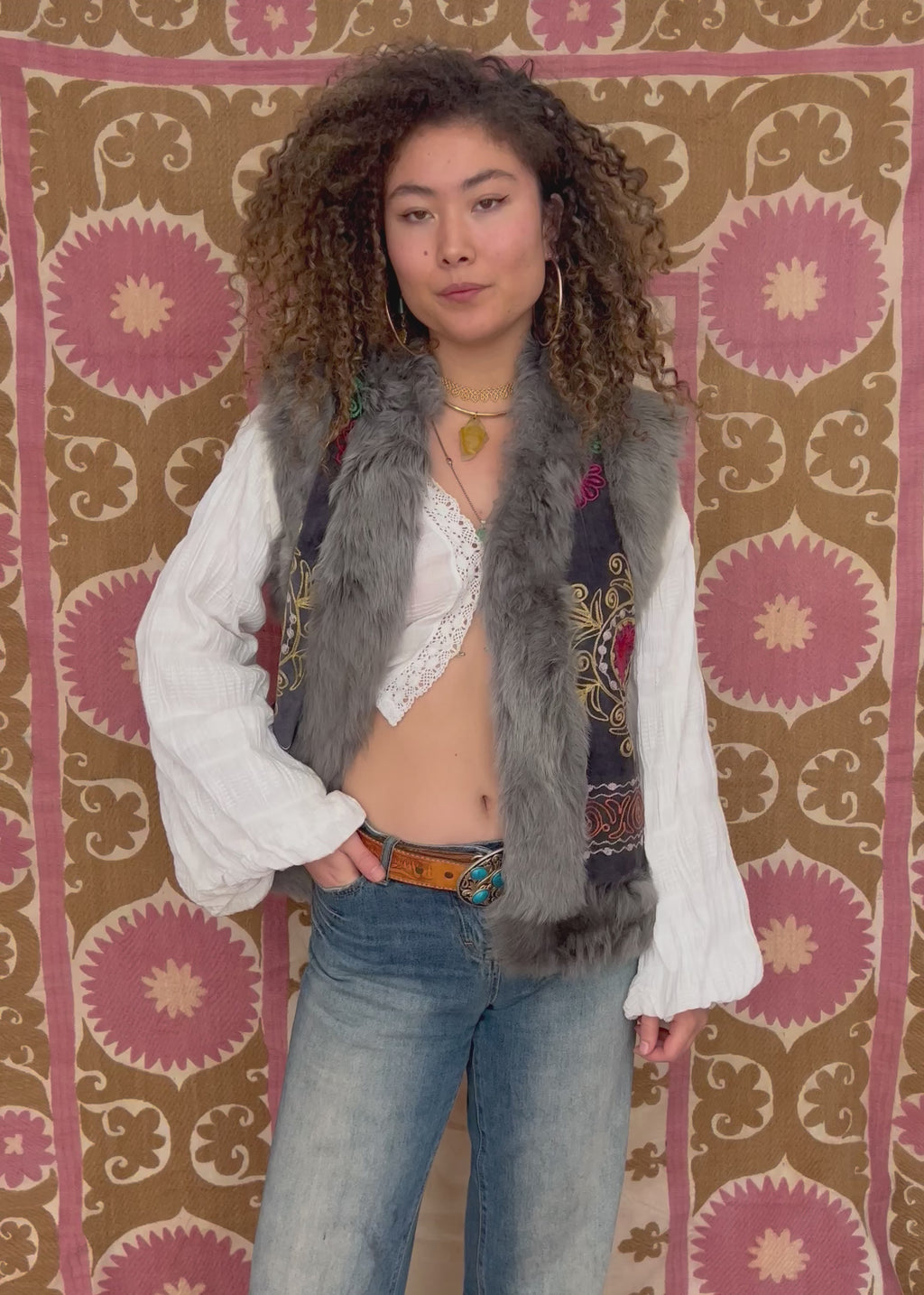 video of model posing in embroidered jewel pattern suzani fur vest